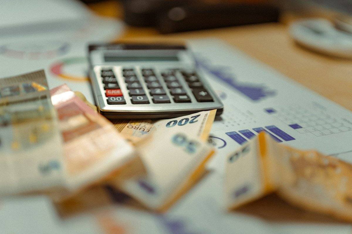ماشین حساب و اسکناس؛ تصویر مفهومی محاسبه بودجه تحصیل